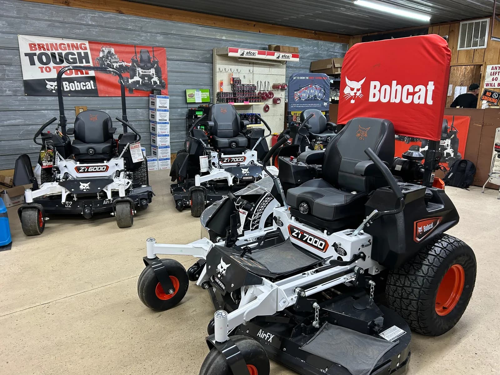 Dutton Small Engine shop interior with Bobcat mowers and parts
